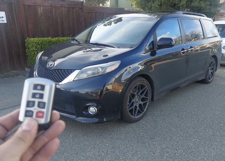 Replacement proximity key fob held in front of a 2018 Toyota Sienna after an all-keys-lost job in Hometown, Illinois.